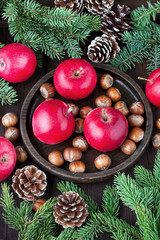 Red winter apples with nuts and fir-tree branches