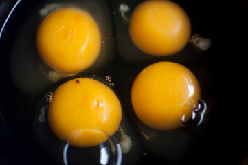 Fototapeta na wymiar Close up of four eggs in a black bowl.