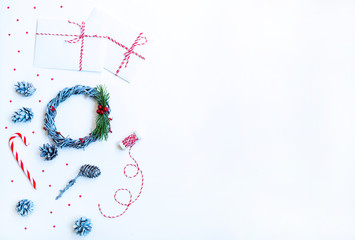 Christmas composition. Gifts, fir tree branches with cones, red decorations on light background. Christmas, winter, new year concept. Flat lay, top view, copy space.
