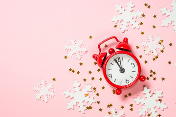 Christmas flat lay background with red clock and decor on pink.