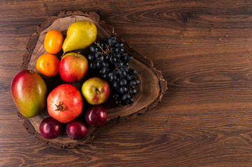 Fruit still life on wooden background. Saw cut of a tree