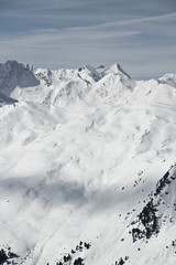 Fototapeta na wymiar Blick von der Axamer Lizum in Tirol auf die schneebedeckten Berge und Gipfel. Neuschnee im Winter. Lawinen Steilhang