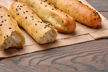 Homemade cheese bread sticks with sesame seeds on a dark wooden background