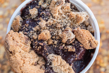 Acai in cup with cookie and on wooden background with granola
