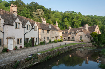 CASTLE COMBE, COTSWOLDS, UK - MAY 26, 2018: Street view of old riverside cottages in the picturesque Castle Combe Village, Cotswolds, Wiltshire, England - UK