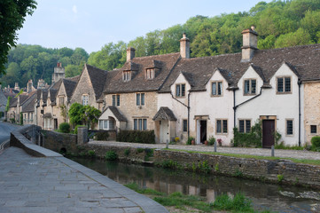 Fototapeta na wymiar CASTLE COMBE, COTSWOLDS, UK - MAY 26, 2018: Street view of old riverside cottages in the picturesque Castle Combe Village, Cotswolds, Wiltshire, England - UK