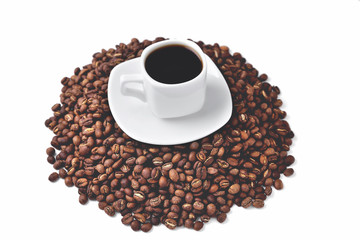 white cup of coffee on a white saucer stands on a hill of coffee beans on a white background isolate, angle view from above