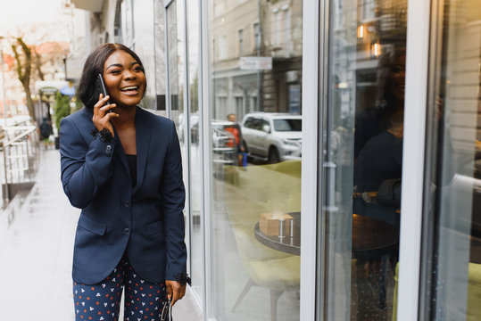 A pretty African american business woman talking on a cell phone at office building