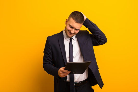 young handsome businessman against flat background with a tablet