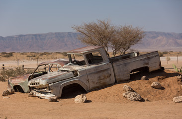 Abandoned old rusty wrecked historic car near a service station at Solitaire in Namibia desert ear...