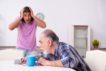 Young student and his old grandpa at home