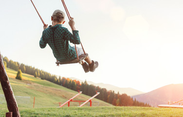 Little Boy swinging on the mountain kids park playground