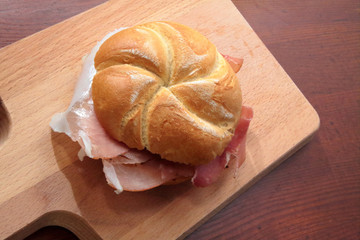 sandwich with speck on wooden cutting board