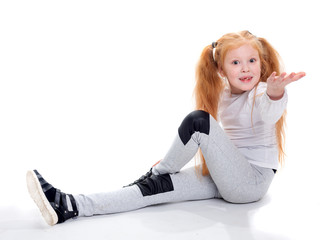 Fototapeta premium Red haired girl sitting on a white background and asking pulls his hand