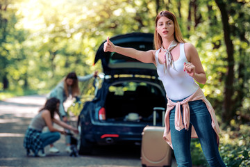 Obraz na płótnie Canvas Girls with a broken car on the road