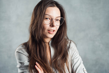 Young brunette woman in glasses, self-confidence. Smiling and calm girl