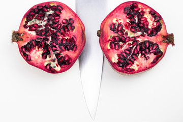 Pomegranate cut in half against a white background