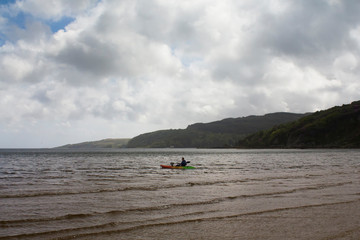 Kayakers on a beach in Scotland on a spring morning. 