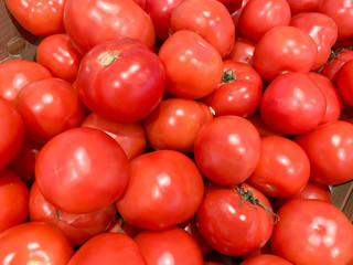 Many delicious red tomatoes in supermarket, whole fresh organic vegetables for sale at a farm market