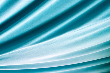 Turquoise natural draped woven fabric with soft pleats, background