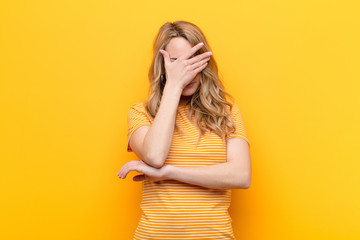 young pretty blonde woman looking stressed, ashamed or upset, with a headache, covering face with...