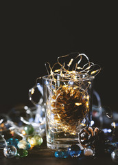 Glowing Christmas Lights and golden pine cone in a glass jar,Christmas decoration background.