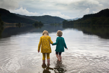 Two small children playing in a Scottish loch