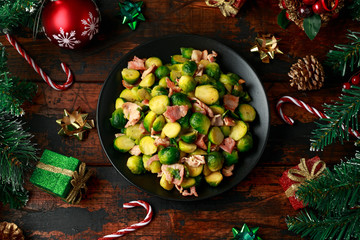 Christmas Brussel Sprouts and Bacon with decoration, gifts, green tree branch on wooden rustic table