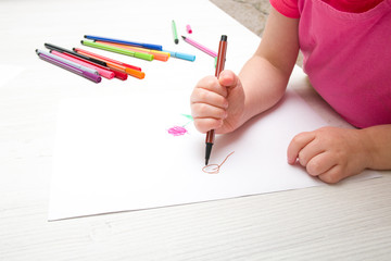 girl draws a balloon on paper with felt-tip pen copy space