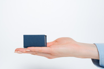 Open female palm with a blue box. Present. White background