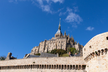 Abbey and ramparts of Mont Saint-Michel against blue sky