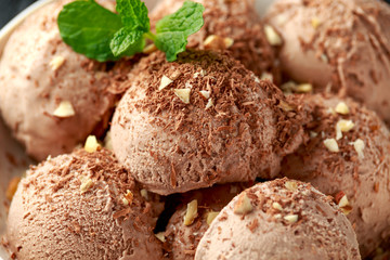 Chocolate Ice Cream with dark chocolate bars and hazelnuts in a white bowl