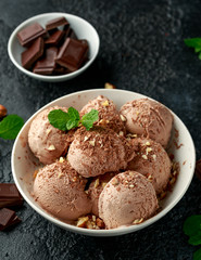 Chocolate Ice Cream with dark chocolate bars and hazelnuts in a white bowl