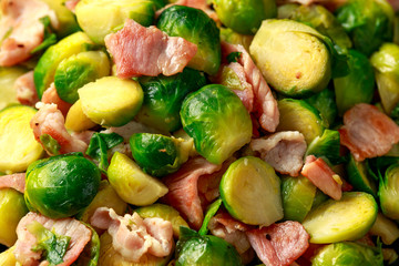 Roast Brussel Sprouts with Bacon on black plate. wooden table