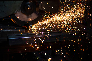 A man processes metal with a grinder.