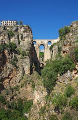 Fototapeta premium Ponte Nuevo (the New Bridge) in Ronda, Spain. This bridge spans the 120-metre-deep (390 ft) chasm that carries the Guadalevín River and divides the city of Ronda