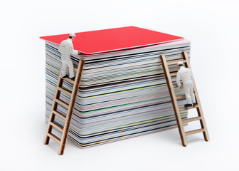 Little men remove a plastic red card from the top of the deck