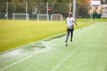 Obraz premium The girl runs on time. Competition in the stadium.