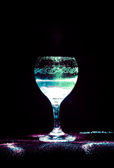 Drink in wine glass on black background