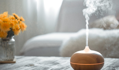 Humidifier on the table in the living room. - obrazy, fototapety, plakaty