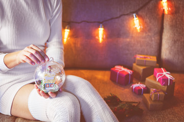 Winter holidays background with woman in wool dress and socks, Christmas gifts and garland