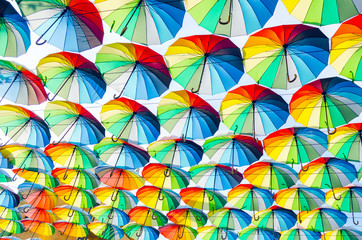 Fototapeta na wymiar Hanging multicolored colorful umbrellas adorn the alley, street decoration