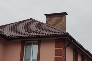  facade with windows under a brown tiled roof against the sky
