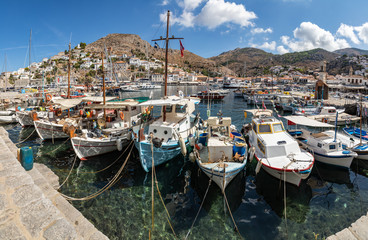 Fototapeta na wymiar Panorama of Boats in the pier with houses and buildings in background in Hydra Island