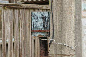 iron gray box for electricity on a concrete pillar street