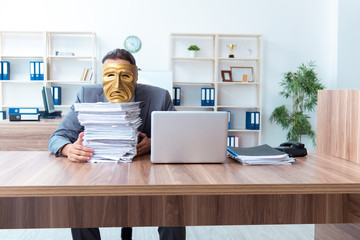 Businessman wearing mask in hypocrisy concept