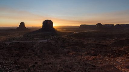 Monument Valley's landscape at sunset. Sun rising behind the Merrick Butte