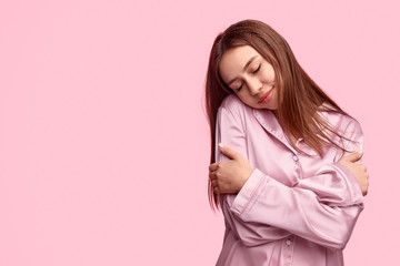 Young woman embracing body during sleep