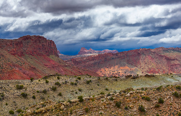 Rocky mountainsides under a cloudy sky in Arches National Park.