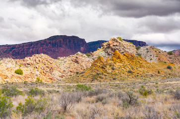 Rocky mountainsides and grassy plain in Arches National Park.